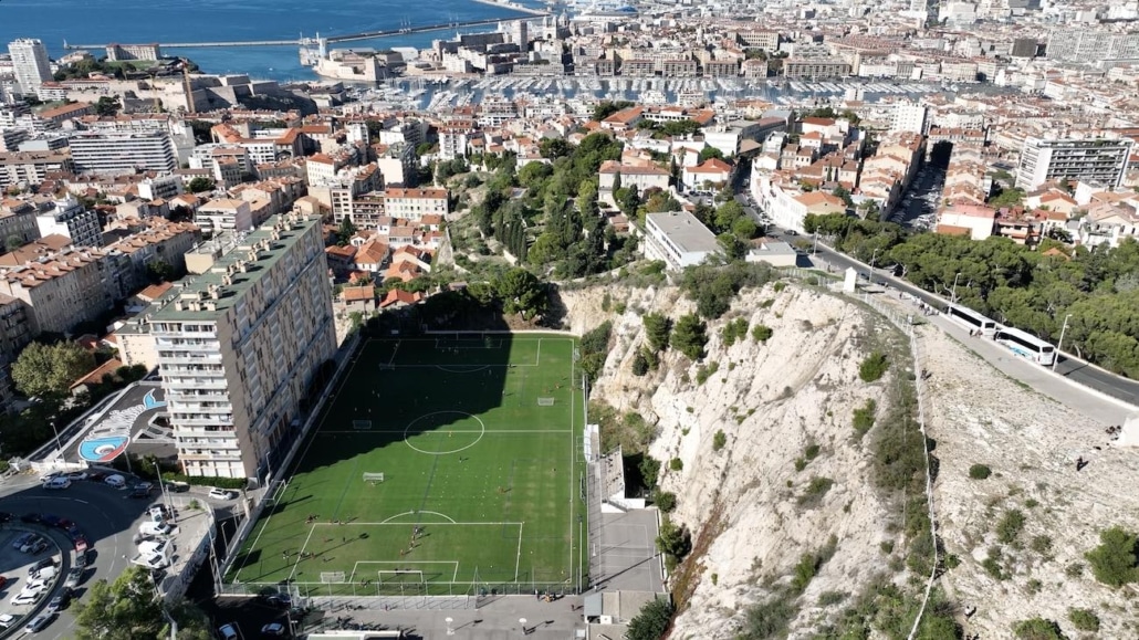 entreprise de drone à marseille : prise de vue aérienne d'un stade marseillais avec le vieux port en fond