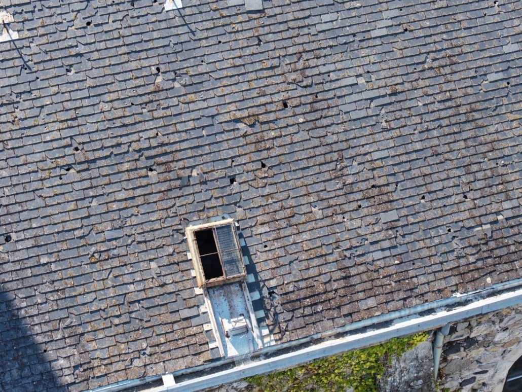 Toiture en ardoise endommagée près d’une lucarne, église d’Aubenas, vue par drone