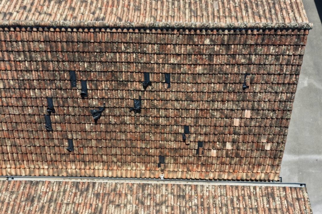 Tuiles cassées et trous dans une toiture, photographiés par drone sur un bâtiment communal à Ucel